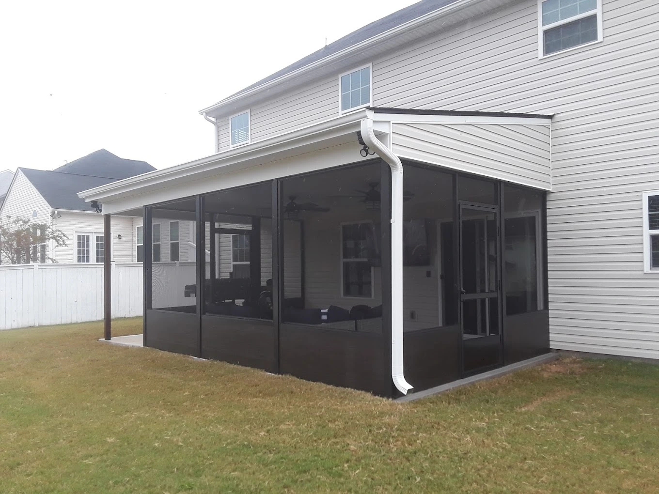 Aluminum screened porch enclosure with outdoor living furniture built in Upstate South Carolina