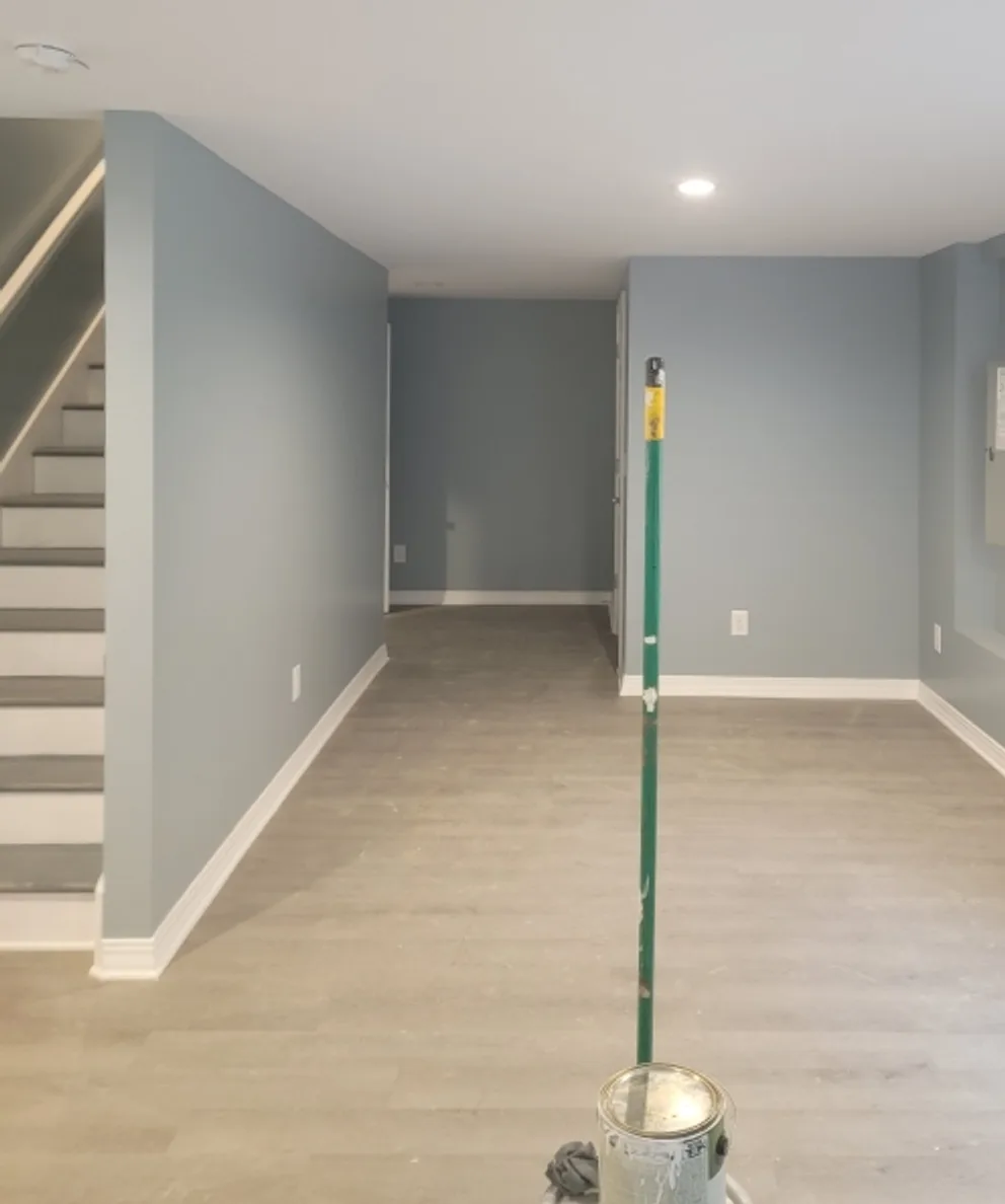 Finished basement with a new staircase, painted walls, recessed lighting and wide-plank vinyl flooring
