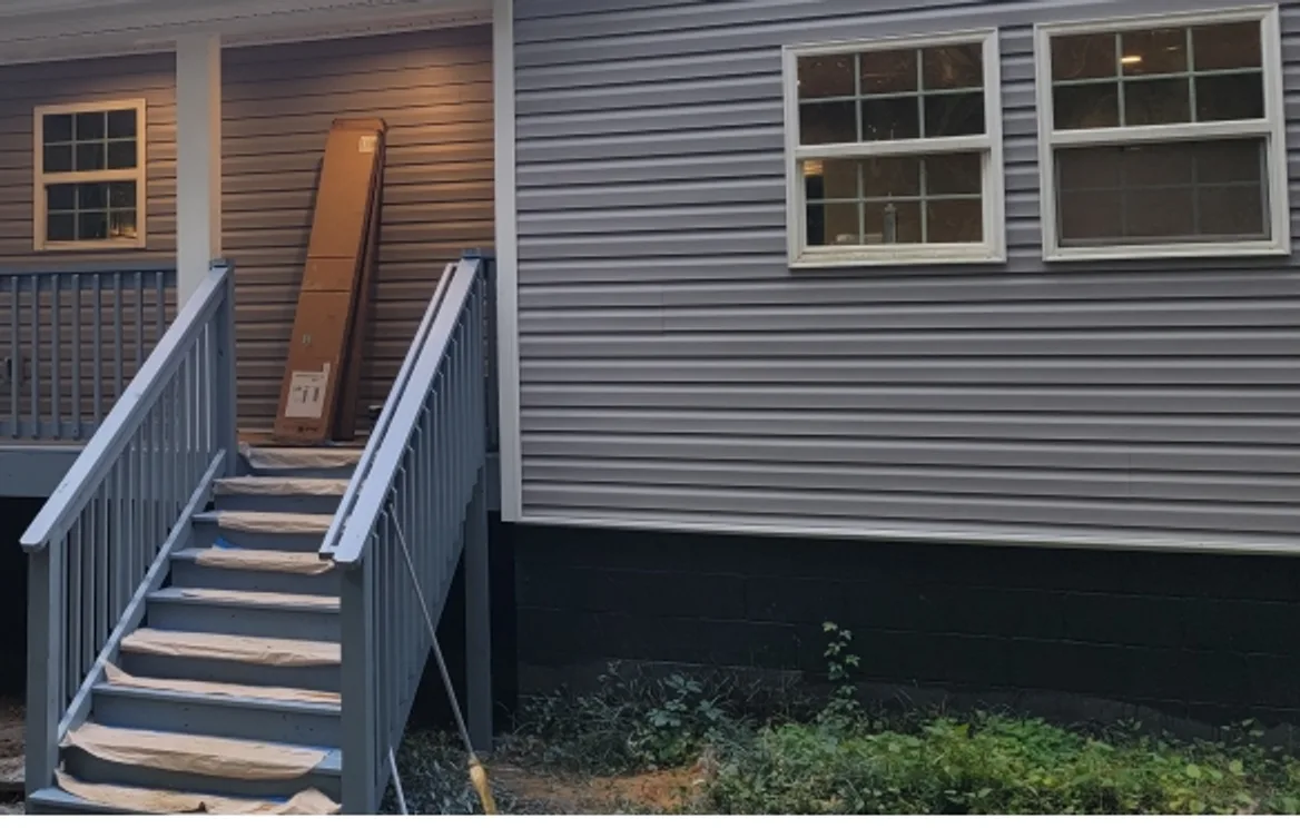 Whole-home remodel with new siding, windows and a covered porch with painted stairs and railings